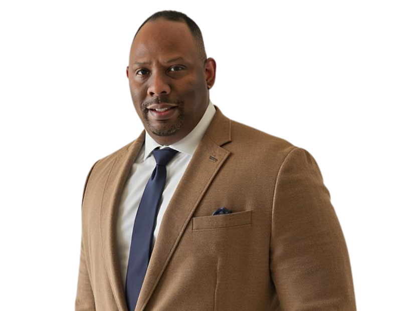 Darrick McDuffie in a tan suit jacket, white shirt, and navy tie, standing against a light blue and white background.