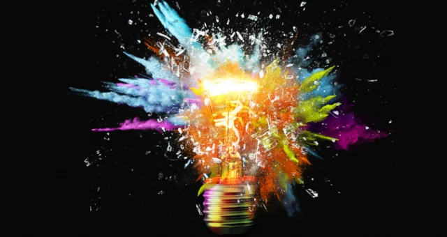 Light bulb shattering with colorful dust coming out everywhere