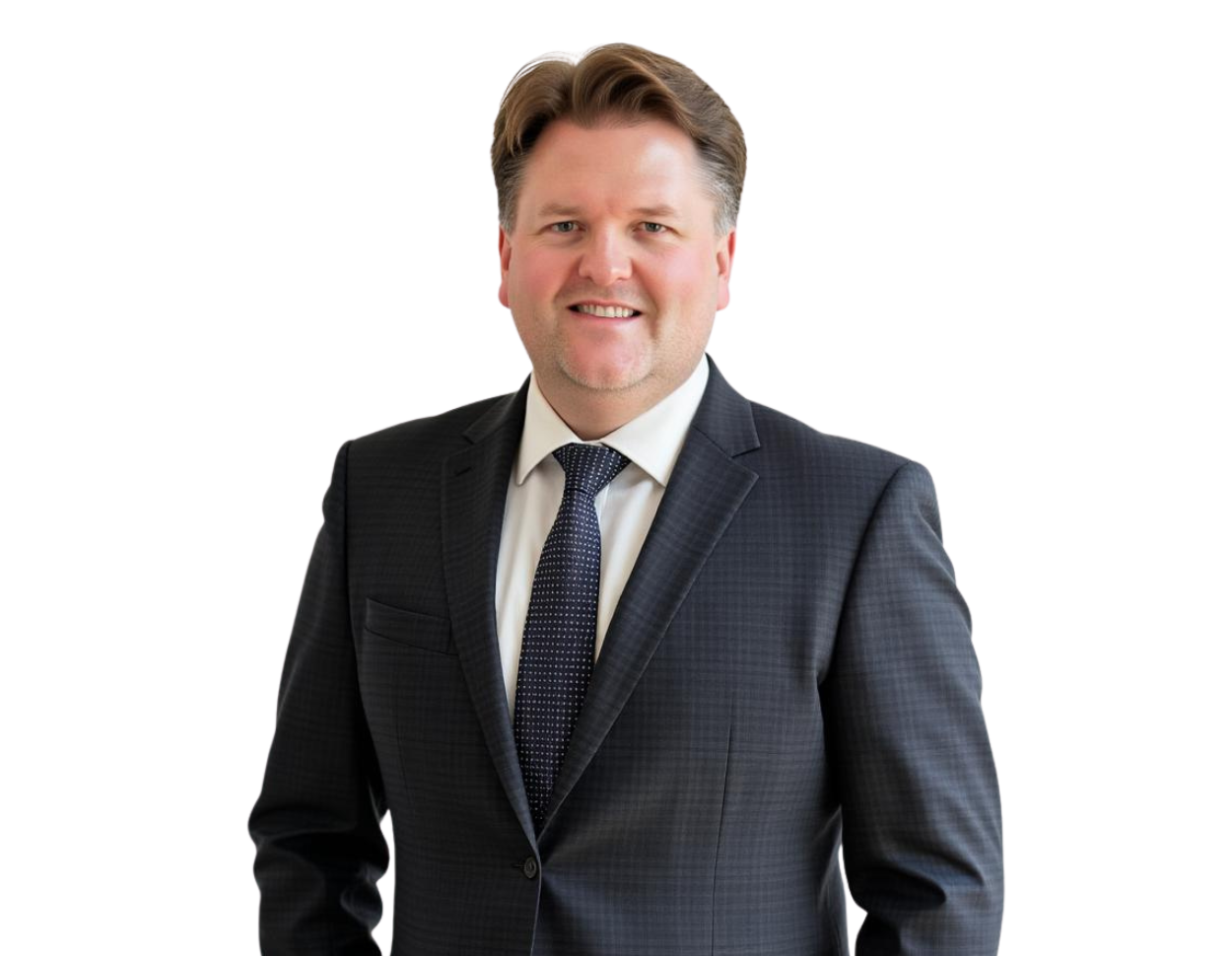 Joseph McNelis wears a dark checkered suit, white shirt, and patterned tie, smiling against a light blue and white geometric background.