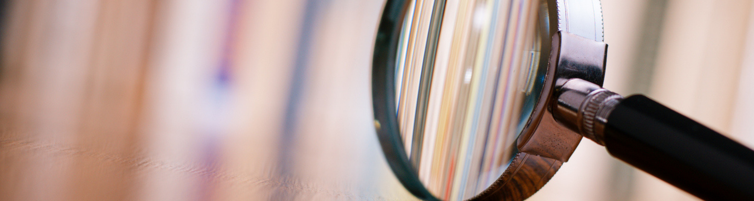 Close-up of magnifying glass with abstract background out of focus