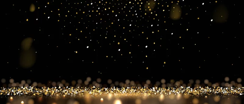 Dark background with gold glitter falling and collecting on the ground