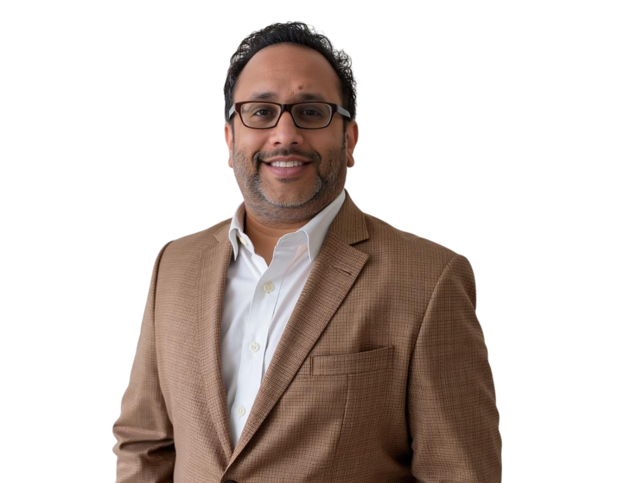 A man with short dark hair and glasses smiles while wearing a light brown plaid blazer over a white dress shirt. He is posed against a plain background, conveying a professional and approachable demeanor.