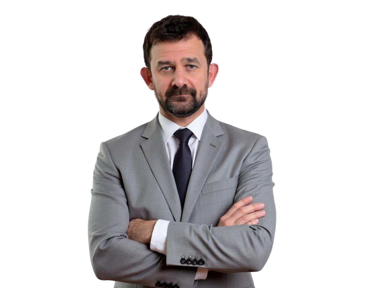 Serious-looking man with short dark hair and beard wearing a light gray suit and dark tie, standing with arms crossed against a transparent background. His formal attire and posture suggest a professional or executive portrait.