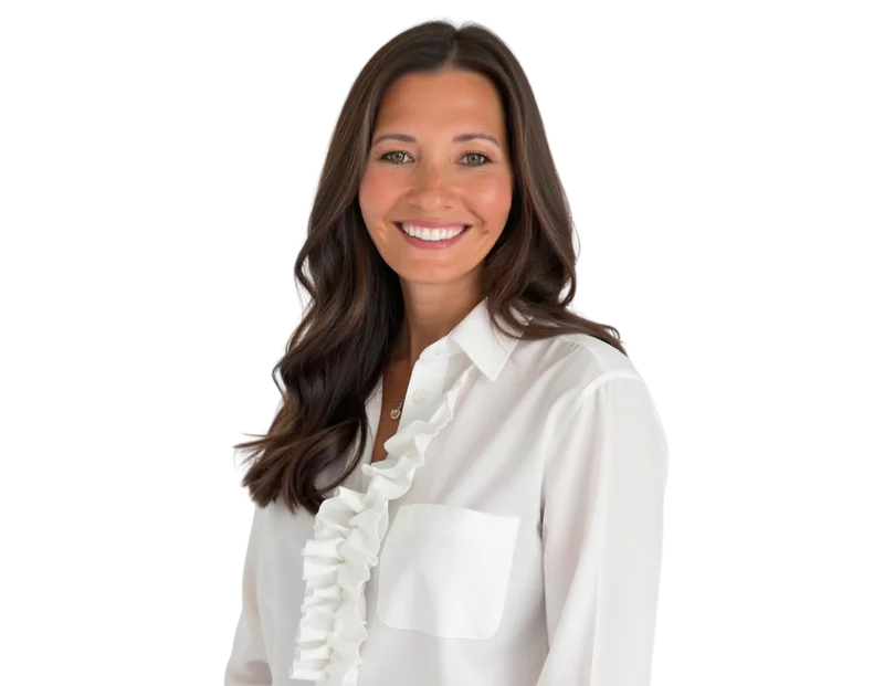Professional headshot of Brooke Nixon smiling, wearing a white blouse with ruffle detailing and a front pocket, with long dark brown hair styled in soft waves against a light background.