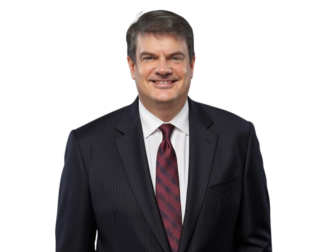 A professional headshot of a man wearing a dark pinstripe suit, white dress shirt, and a maroon patterned tie, smiling confidently. The background has been removed, making the image suitable for corporate profiles or executive bios.