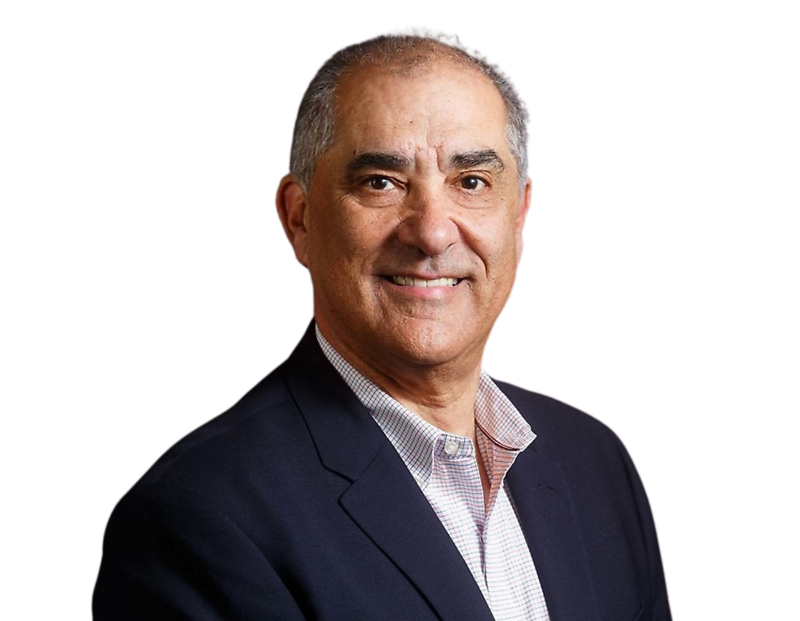 Frank Shuster wearing a dark blazer over a light checkered shirt against a plain background.