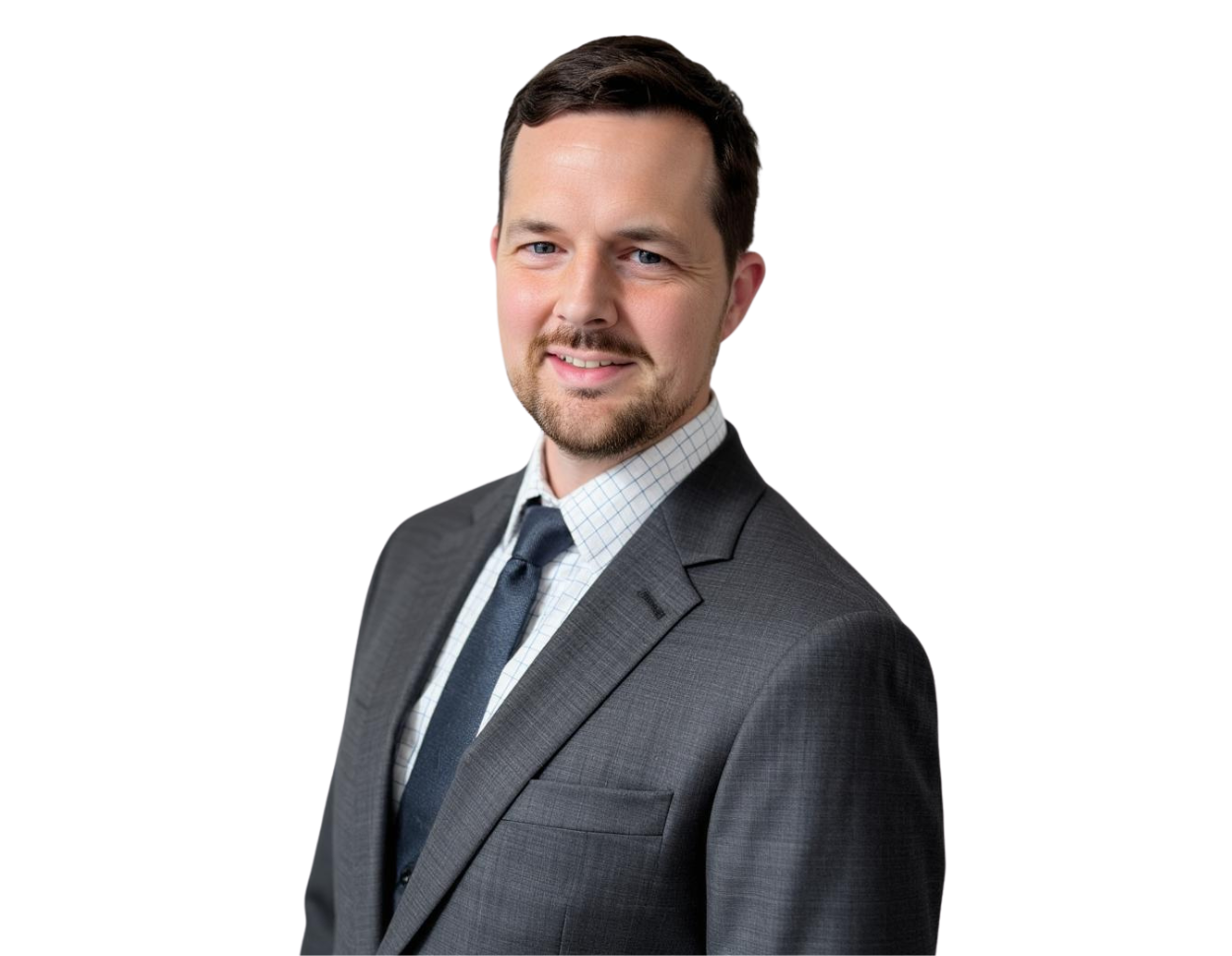 Robert Wennagel in a professional headshot, smiling and wearing a gray suit with a checkered dress shirt and dark tie, set against a transparent background.