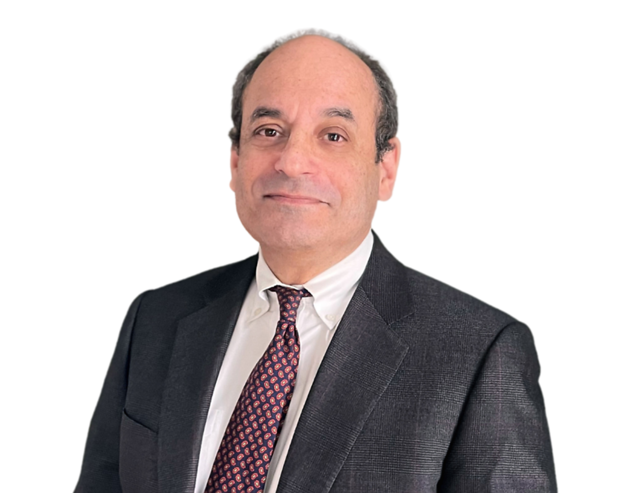 Older man with a receding hairline wearing a dark checkered suit, white dress shirt, and a red paisley tie, posing with a slight smile against a transparent background. His formal appearance and composed posture reflect a professional or executive role.