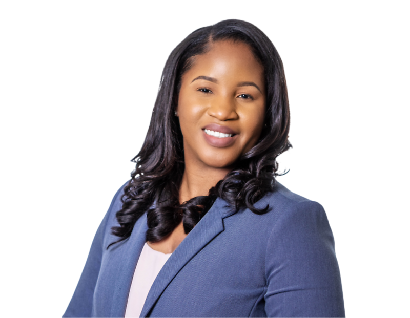 Smiling woman with long, styled black hair wearing a light pink top and a slate blue blazer, posed confidently against a transparent background. Her posture and attire suggest a professional headshot for business or corporate use.