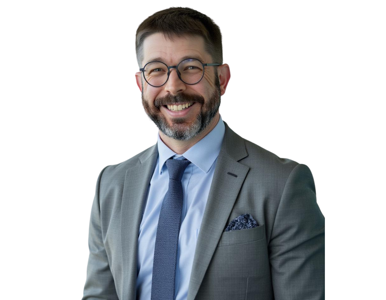 Smiling professional man with short dark hair, beard, and round glasses, wearing a light gray suit with a light blue shirt, patterned pocket square, and navy tie. He stands against a transparent background, giving off a warm and approachable executive pre