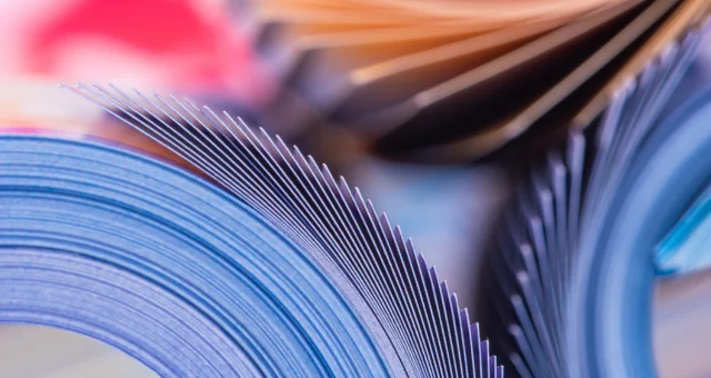 Colorful magazine pages open at various angles