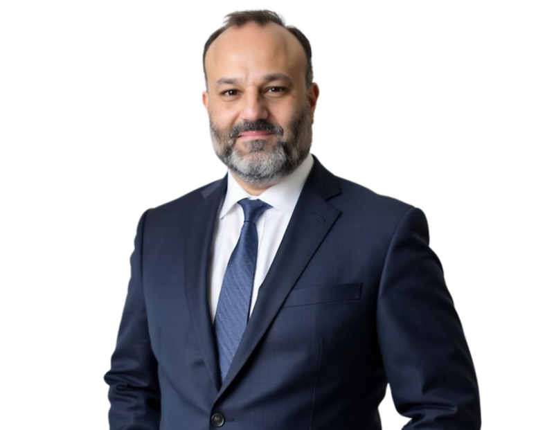 Jon Persky, partner, wears a dark navy suit and tie, standing against a light blue and white geometric background.