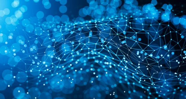 Abstract digital background featuring a blue network of interconnected points and lines over a softly blurred bokeh effect. The image conveys concepts of connectivity, data flow, and advanced technology systems.