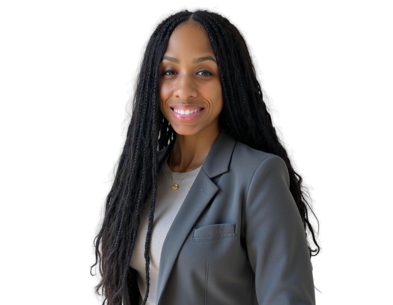 A woman with long, braided hair smiles confidently while wearing a gray blazer over a light beige top. She stands against a transparent background, dressed in professional attire with a gold pendant necklace, exuding warmth and professionalism.