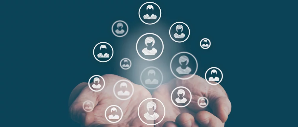 Open hands held upward with floating circular user profile icons hovering above them against a teal background. The softly glowing avatars vary in size, suggesting different individuals within a network.