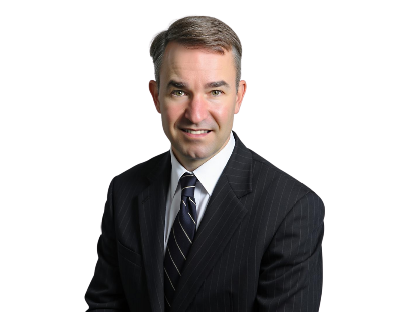 Jonathan Martin, wearing a dark pinstripe suit and striped tie, poses against a black background with a slight smile. His short brown hair is neatly combed to the side.