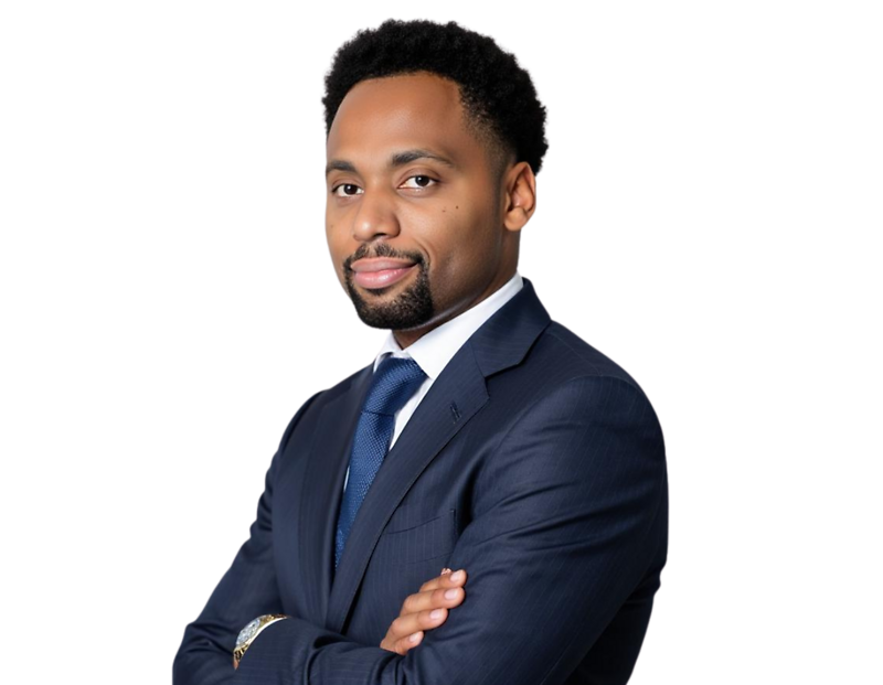 Professional man with short, neatly styled hair and a trimmed beard wearing a dark navy suit with a white shirt and blue tie, standing with arms crossed against a transparent background. He has a confident, poised expression suitable for executive or busi