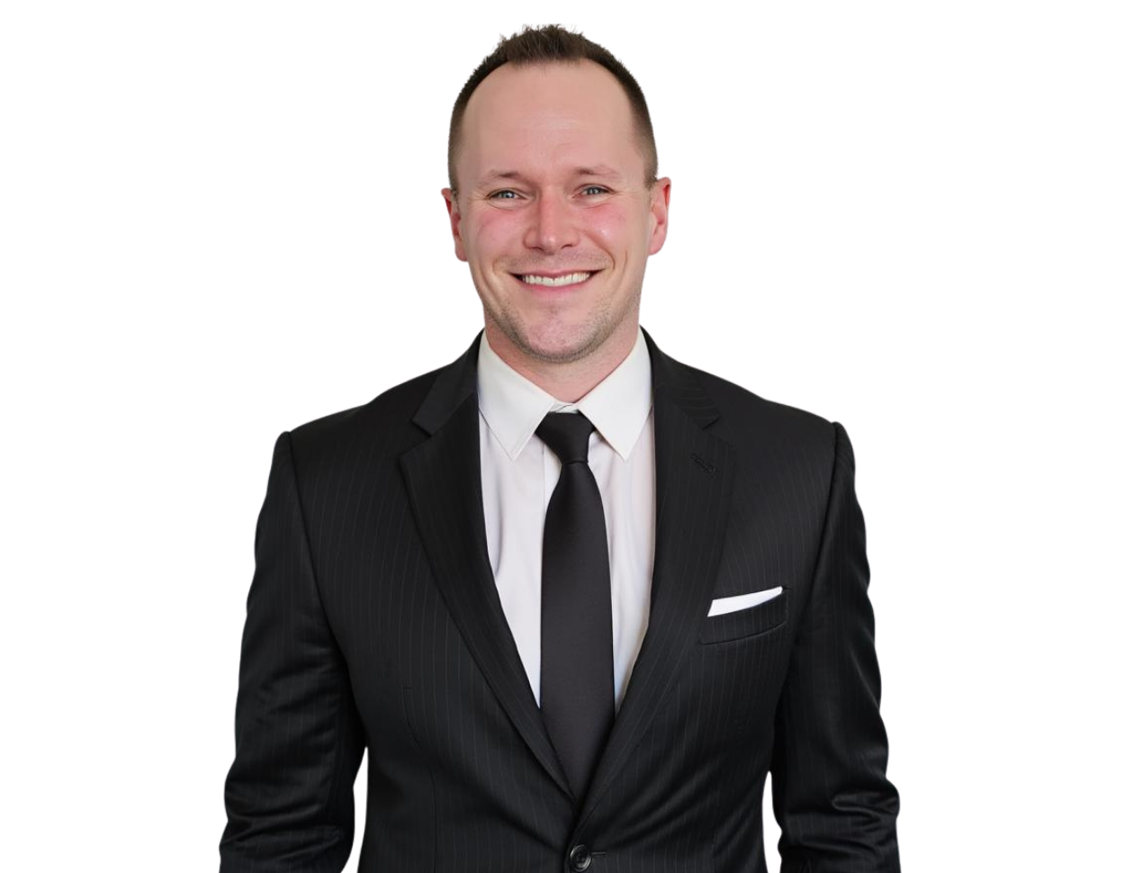 Smiling professional man with short light hair wearing a black pinstripe suit, white dress shirt, and solid black tie, with a white pocket square. He stands confidently against a transparent background, presenting a sharp and formal business appearance.