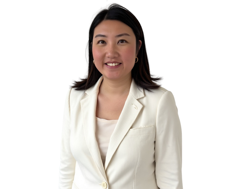 Smiling professional woman with shoulder-length dark hair wearing a textured white blazer over a light top, posing against a transparent background. She has a warm, approachable expression and a polished appearance suitable for business or corporate profi