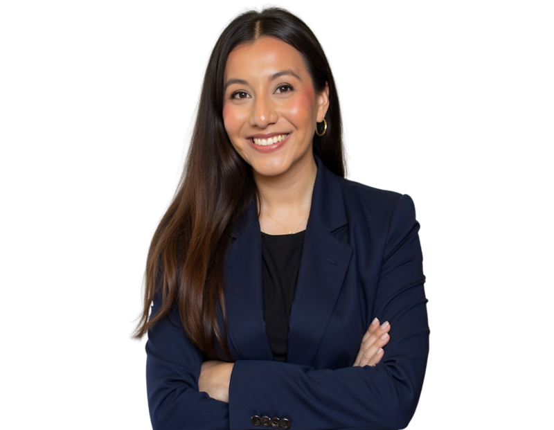 Smiling professional woman with long straight dark brown hair wearing a navy blazer over a black top, standing with arms crossed against a transparent background. She has gold hoop earrings and a warm, approachable expression suited for corporate or execu