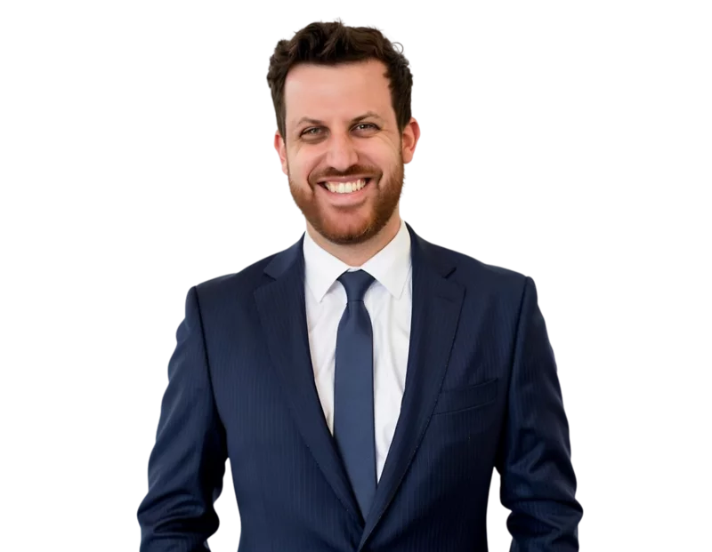 Jason Friedman in a dark navy suit and tie smiles against a light blue and white geometric background.