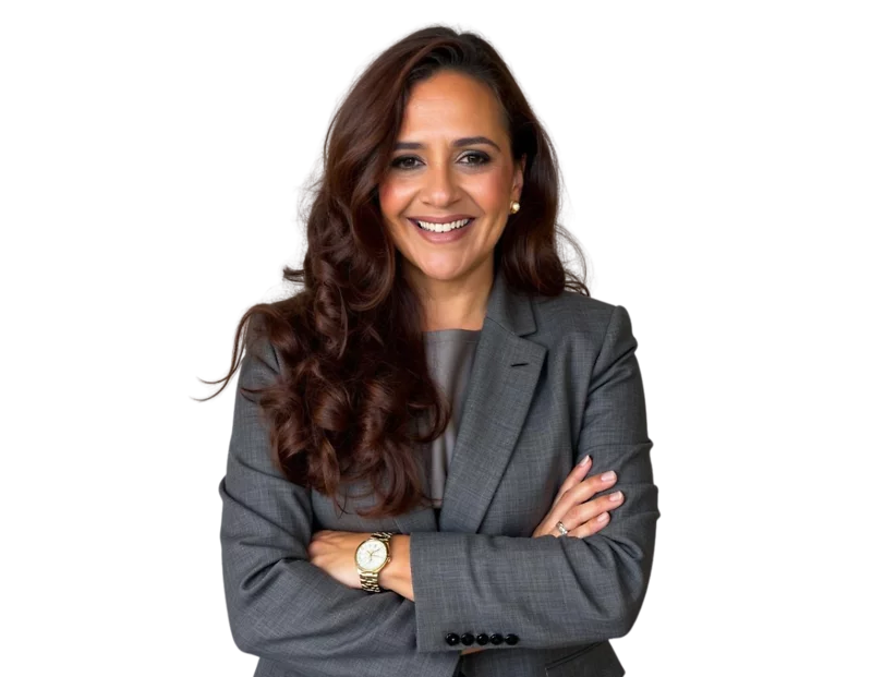 Anjie Cabrera in a gray suit and blouse, smiling in front of a light geometric background.