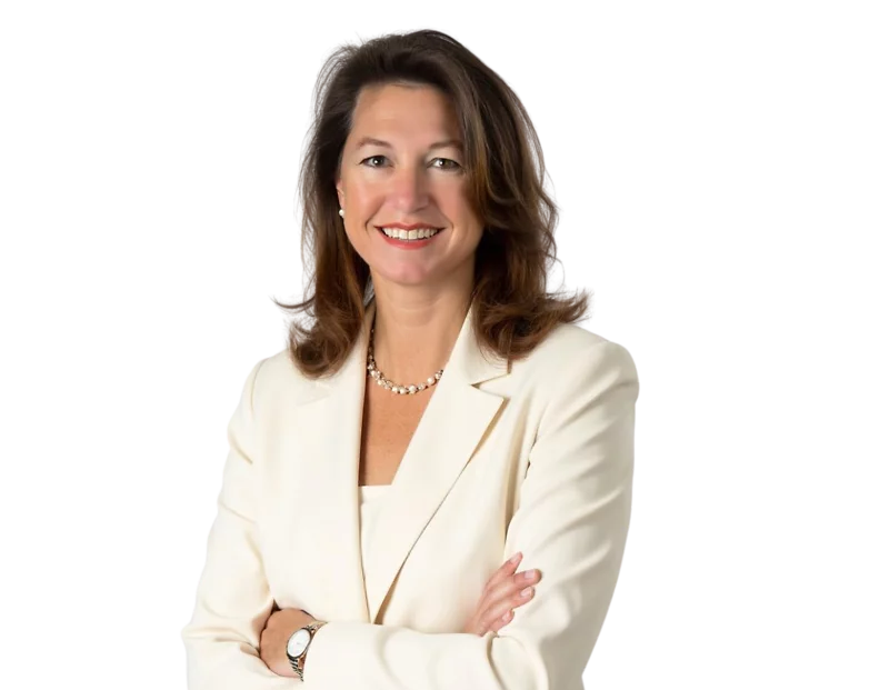 Professional headshot of Maureen Knight with shoulder-length brown hair, wearing a white blazer, pearl necklace, and a confident smile. She stands with her arms crossed against a white background, giving a poised and professional impression.