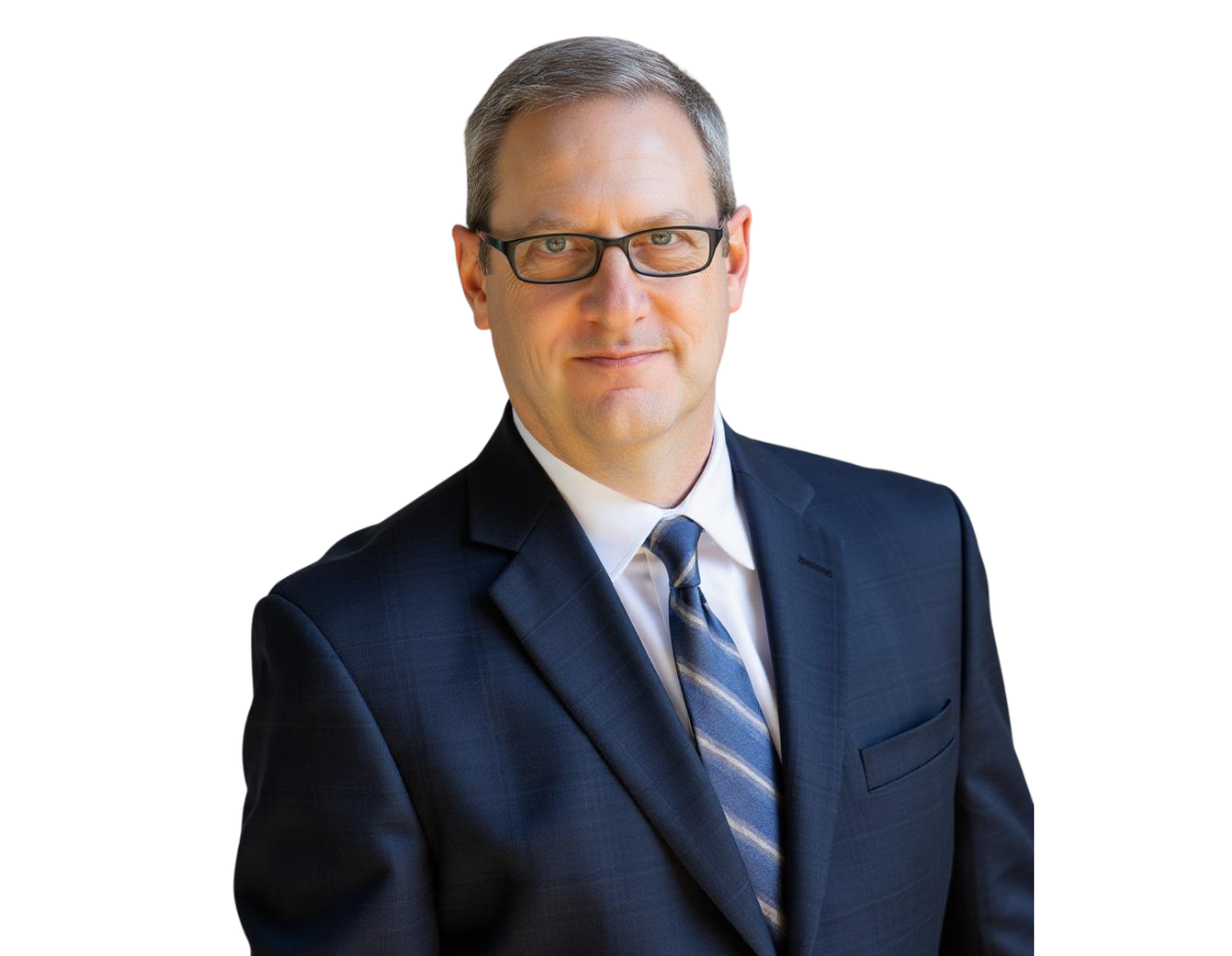 Professional man with short gray hair and glasses wearing a dark blue suit, white dress shirt, and striped tie, standing against a transparent background. He has a confident, approachable expression, ideal for corporate or executive representation.