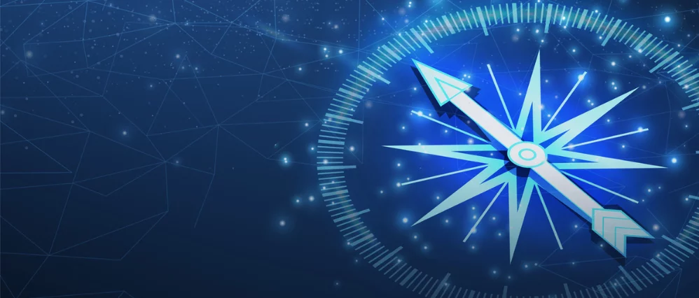 Blue toned digital illustration of a glowing compass centered against a dark textured background. The compass features an eight pointed star design with illuminated lines and subtle particle effects, creating a dramatic and atmospheric look. The image hig