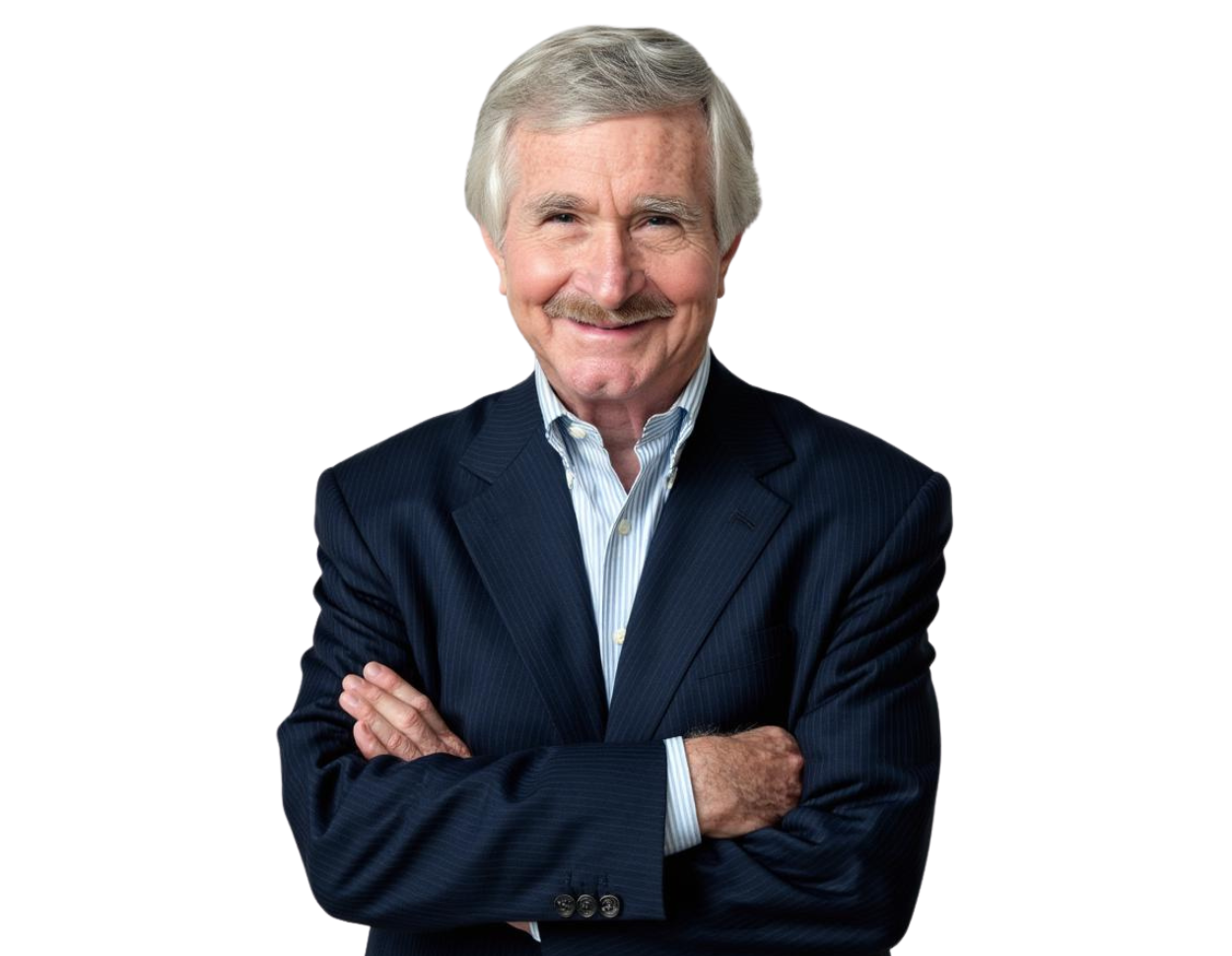 John Doyle wears a dark suit and light blue shirt, smiling with arms crossed against a light blue and white geometric background.