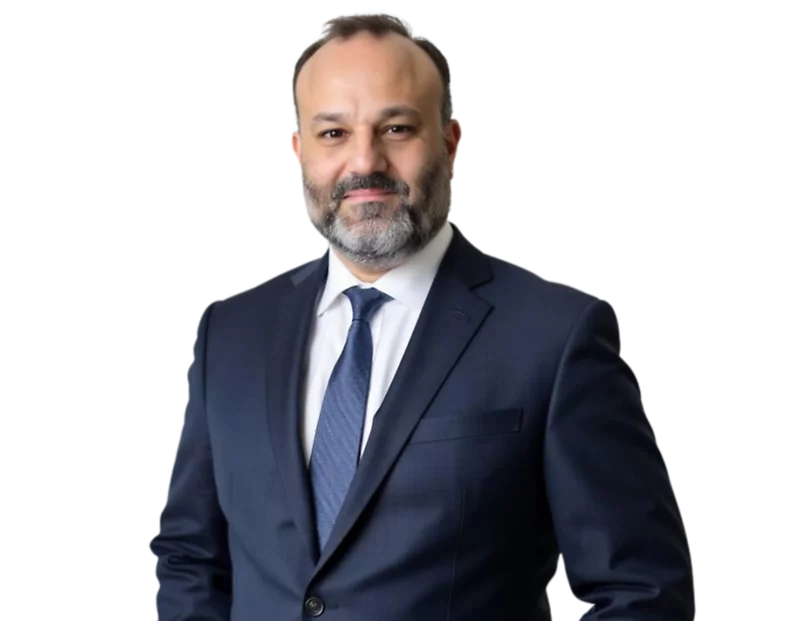 Jon Persky, partner, wears a dark navy suit and tie, standing against a light blue and white geometric background.