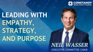 Promotional graphic for "Cyber Heroes. Behind the Firewall. Episode 1" featuring Neil Wasser in a navy suit against a blue digital background. Text reads "Leading with Empathy, Strategy, and Purpose" and "Neil Wasser. Executive Committee Chair" with the C