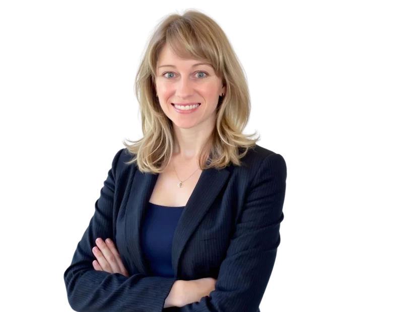 Professional woman with shoulder-length blonde hair wearing a navy pinstripe blazer over a light gray top, smiling with arms crossed. She stands confidently against a plain white background, projecting a friendly and approachable business presence.