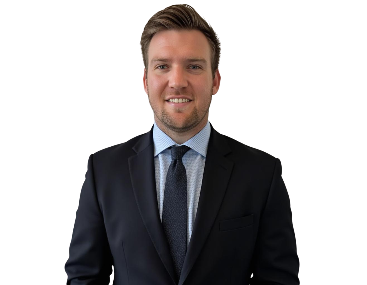 Jadie Mims in a dark suit with a light blue dress shirt and navy patterned tie is smiling at the camera. He has short, neatly styled brown hair and light facial stubble.