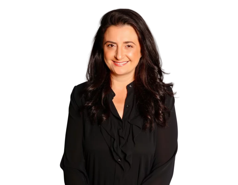 Professional headshot of partner Barbara Antonucci smiling, wearing a black blouse with ruffle detailing and long wavy dark hair, posed against a transparent background.