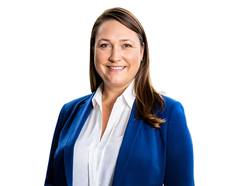 A woman with straight, shoulder-length brown hair smiles confidently while wearing a royal blue blazer over a white blouse. Her professional attire and posture convey a polished and approachable demeanor.