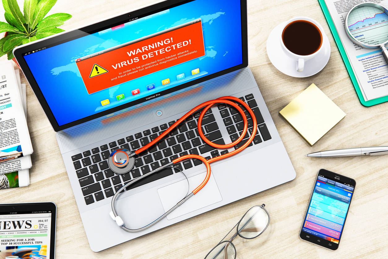 Laptop with virus attack warning message on screen and stethoscope stock photo