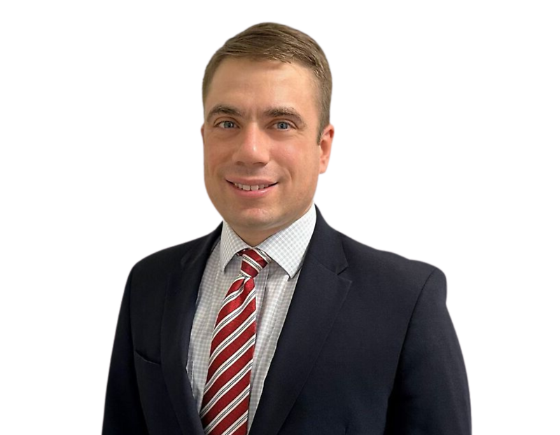 Headshot of Cyber Team partner, Bert Bender, in a navy blue suit, white checkered dress shirt, and red striped tie, posing against a transparent background.