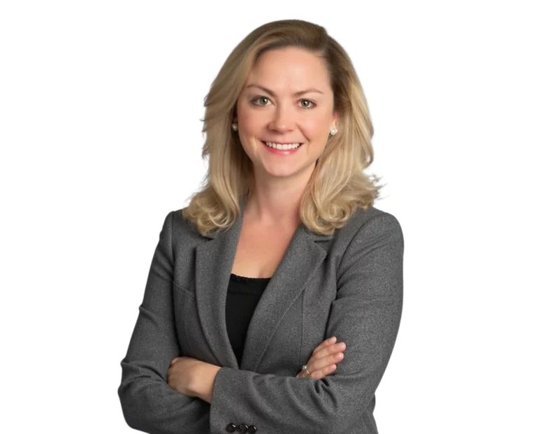 Professional headshot of Anna Schall Kreamer, Senior Counsel of the Constangy Cyber Team. She is smiling confidently with arms crossed, wearing a grey blazer over a black top, and has shoulder-length blonde hair styled in loose waves.
