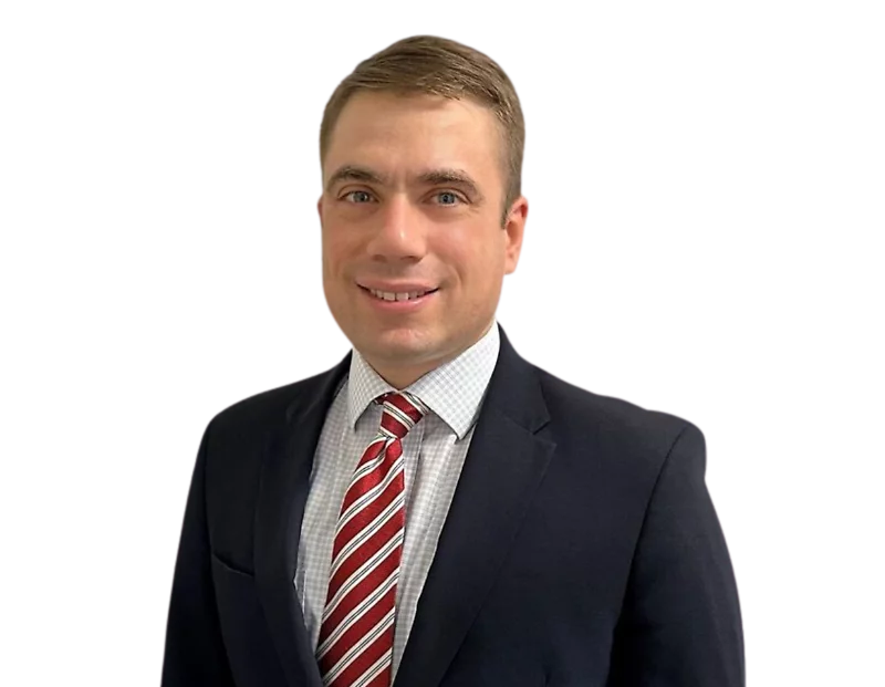 Headshot of Cyber Team partner, Bert Bender, in a navy blue suit, white checkered dress shirt, and red striped tie, posing against a transparent background.