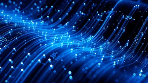 Abstract digital illustration of glowing blue light trails and particles flowing across a dark background, representing high-speed data transfer or fiber-optic network connections. The curved streaks create a sense of motion and advanced technology.