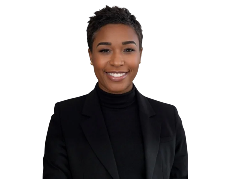 Professional portrait of Leo Tyree smiling, with short dark hair, wearing a black blazer over a black turtleneck and small gold stud earrings. She faces forward and looks directly at the camera with a warm, confident expression.