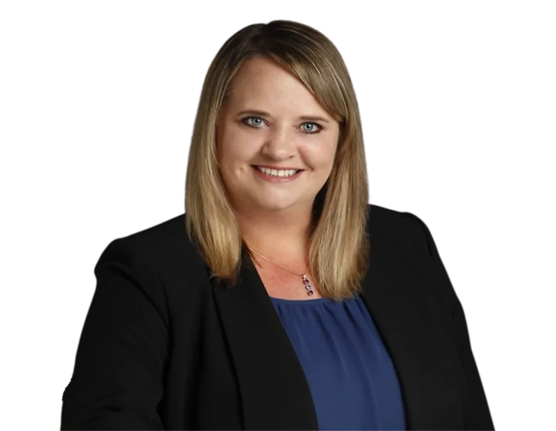 Professional headshot of Angelique Lyons, partner at Constangy, smiling at the camera. She has straight blonde hair, wears a black blazer over a royal blue blouse, and a delicate pendant necklace against a plain background.