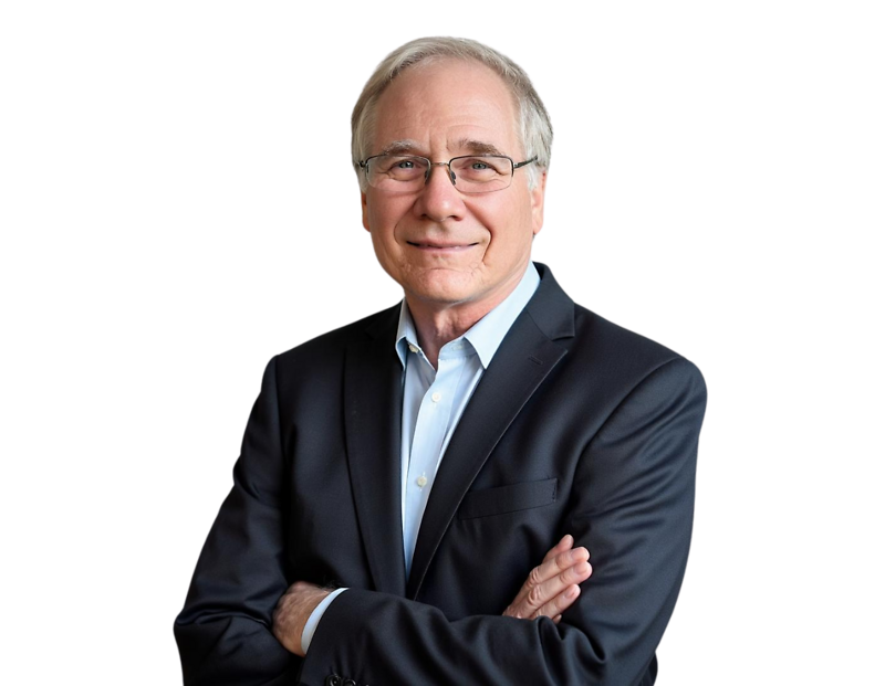 Ken Carlson wearing a dark suit jacket over a light blue dress shirt, arms crossed, posed against a light blue and white geometric background.