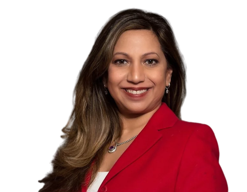 Punam Rogers, smiling, wearing a red blazer over a white top, accessorized with a necklace and earrings, against a plain background.