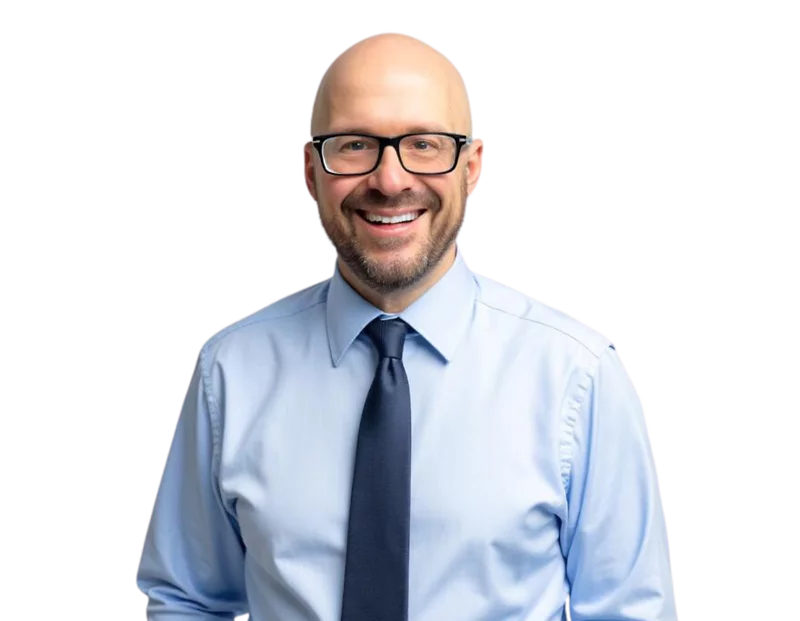 Dave Kurtz in a blue shirt and tie, smiling in front of a light geometric background.
