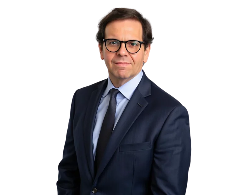 Steve Katz in a dark navy business suit with a light blue shirt and black tie poses for a professional headshot. He has short brown hair, wears black-framed glasses, and looks directly at the camera with a neutral expression.
