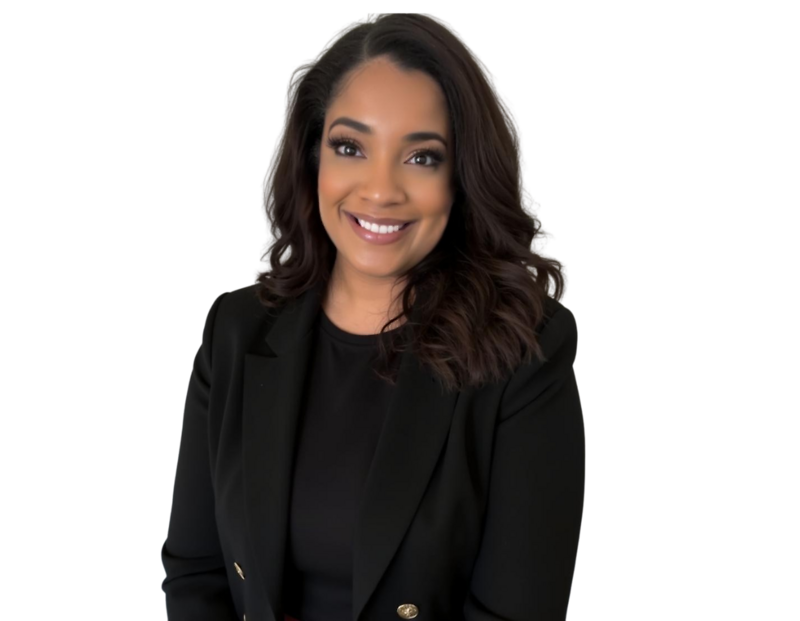 Professional headshot of Taren Greenidge with shoulder-length wavy hair wearing a black blazer and black top, posed against a plain background. She appears confident and professional, with a warm expression and natural makeup.